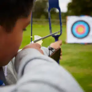 A boy aiming a bow and arrow.