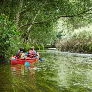 A PGL group canoeing through a river