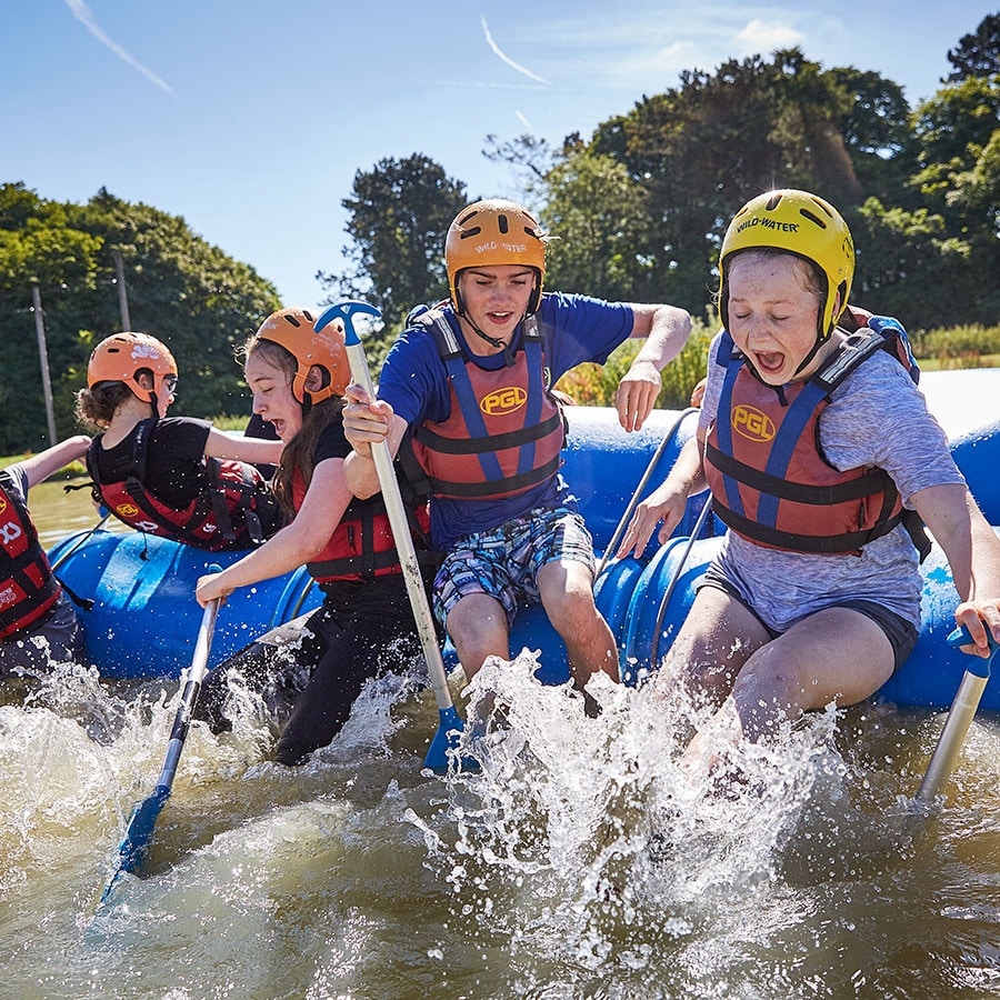 Children jumping off the raft they built themselves in our Reach programmes