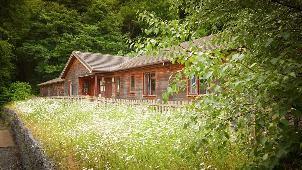 Exterior shot of the wooden lodge available at the Scottish PGL Centre Dalguise