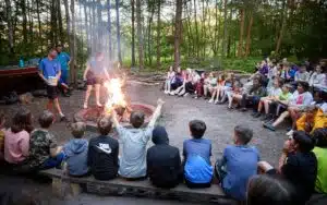 Scouts and PGL instructors gathered around a campfire.