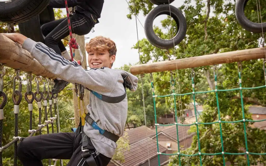 Students on the climbing wall at a PGL centre.