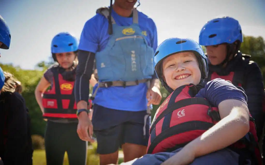 Children in life jackets being taught by a PGL instructor.