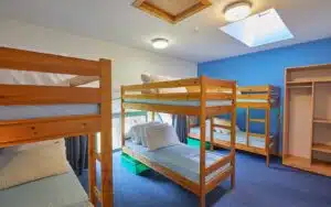 Three bunk beds in a blue room