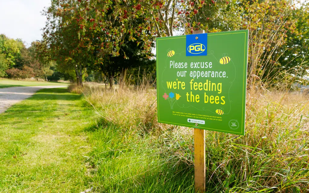 Sign on a grassy path reads, 