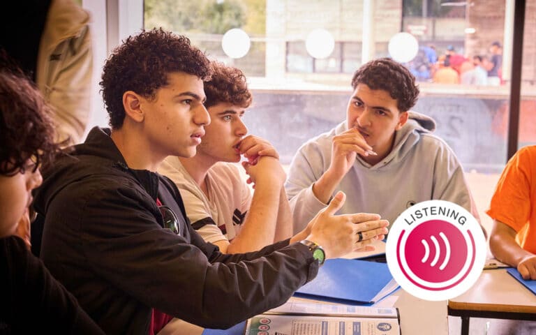Four young people sit at a table in discussion, engaging in multi-activity conversation, with one gesturing while speaking. A "Listening" icon is overlaid in the foreground.