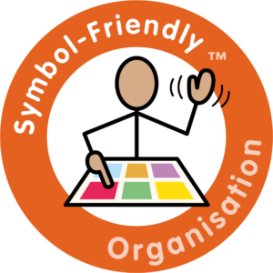 A circular orange logo with the text "Symbol-Friendly Organisation" surrounding a stick figure waving and using a colourful, multi-activity communication board.